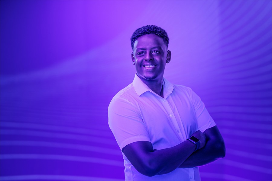 A person in a purple light looks off into the distance.