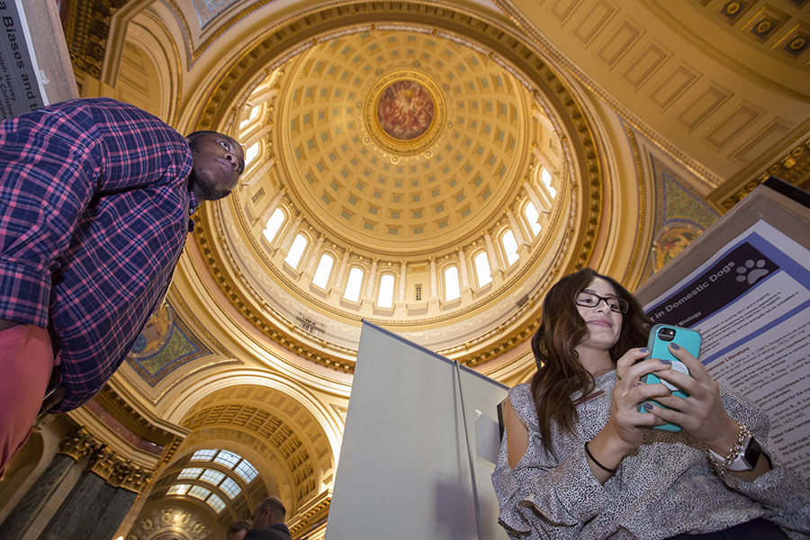 Two students stand in the Rotunda of the Wisconsin State Capitol building.