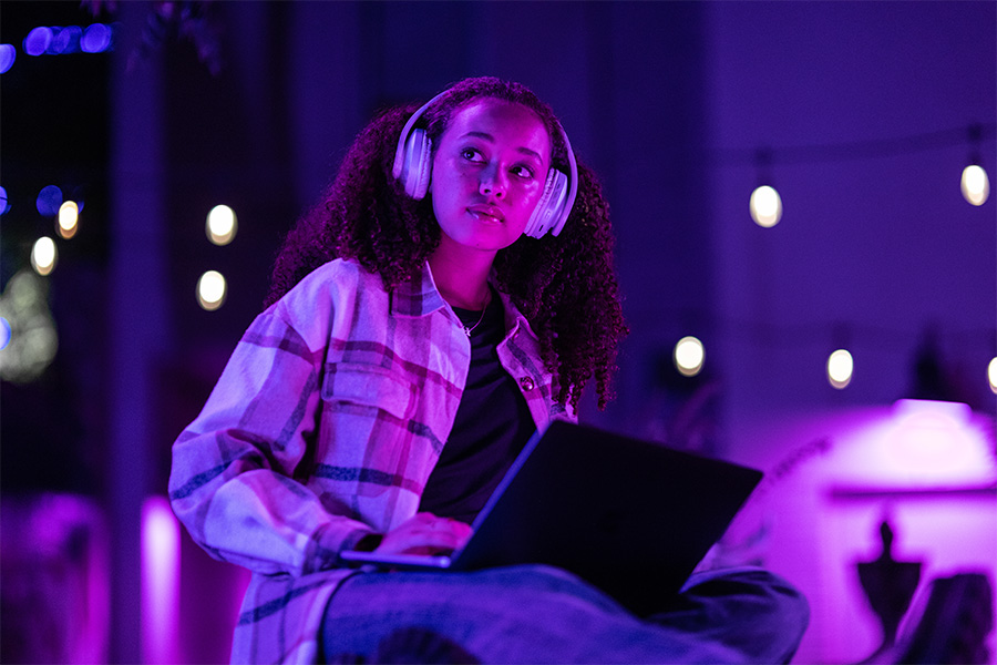 A person wearing headphones works on a laptop.