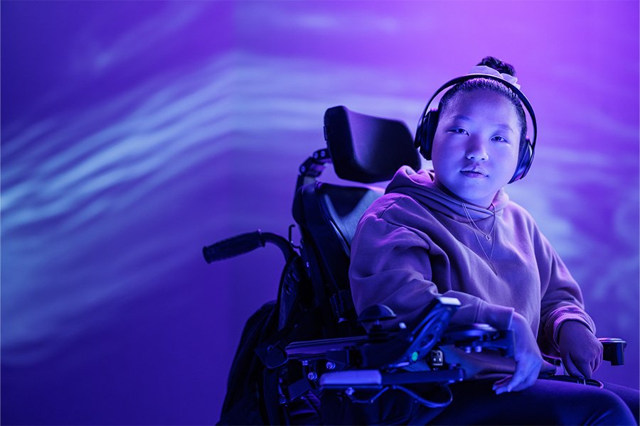 A person in a wheelchair looks into camera.