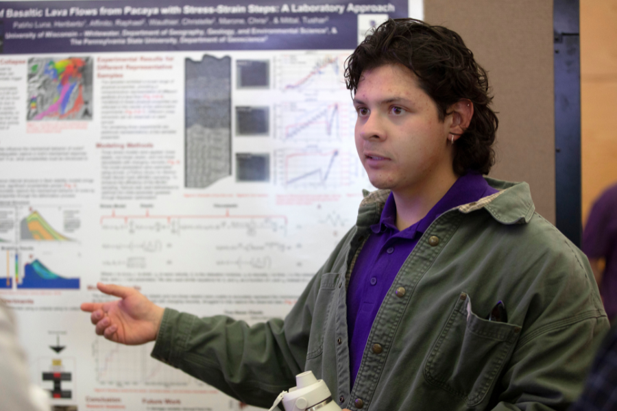 A student points at a white board with research.